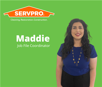 female employee standing in front of green background with servpro logo