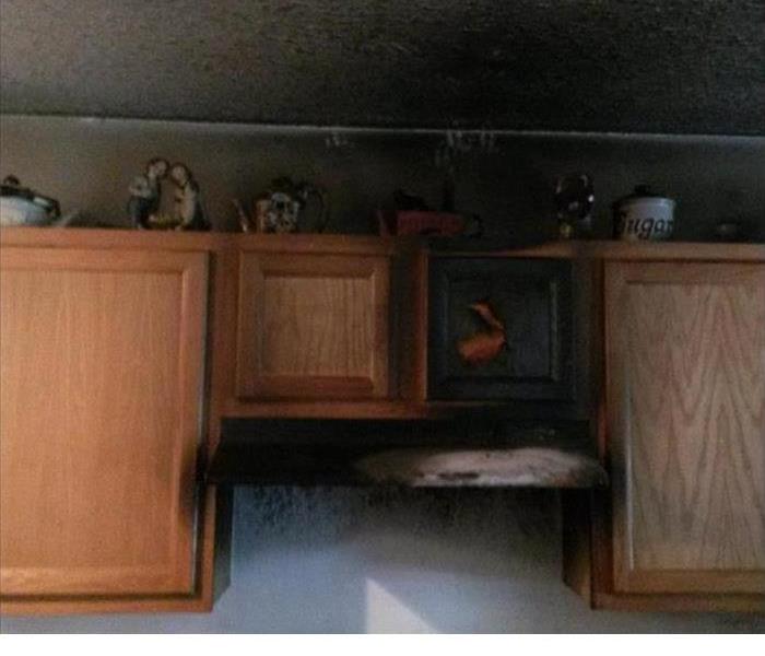 its soot on the walls and cabinets in the brown kitchen after a house fire. 
